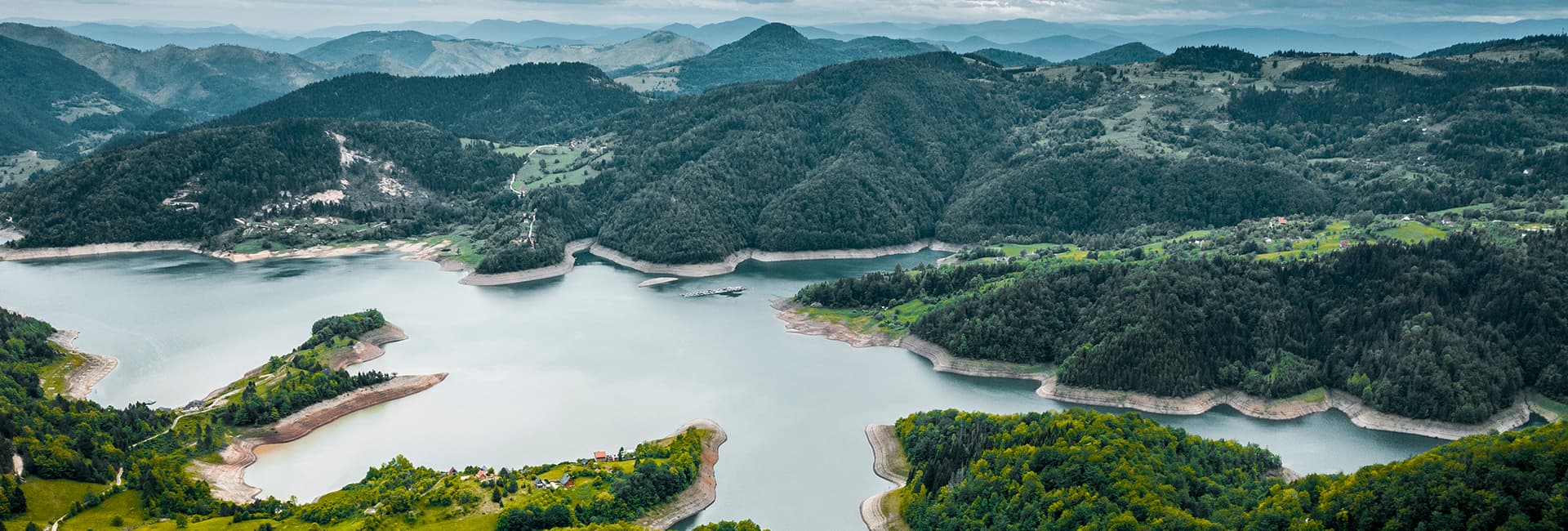 Panoramski pogled na planinsko jezero i pošumljene padine Tare
