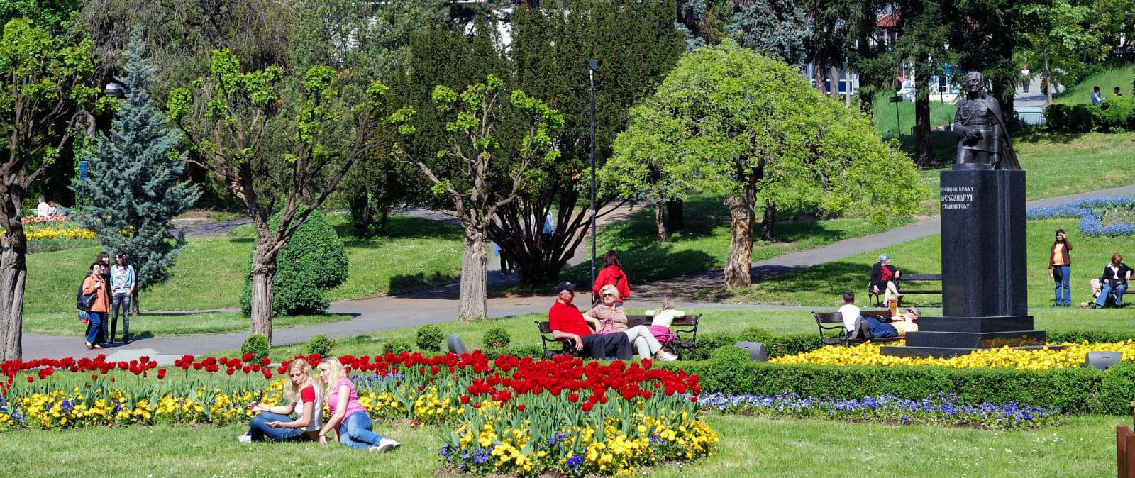 Centralni park Vrnjačke Banje sa cvetnim lejama, zelenilom i spomenikom