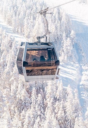 Gondola iznad zasneženih borova na ski-centru Tornik zimi